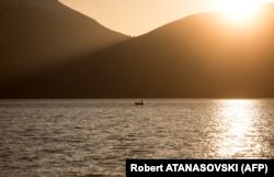 A fisherman enjoys the serenity of Lake Prespa near sunset.