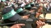 Membrii grupării militante Hamas mărșăluiesc cu puști AK 47 în timpul unui miting în tabăra Bureij din Fâșia Gaza, pe 5 martie 2004.
