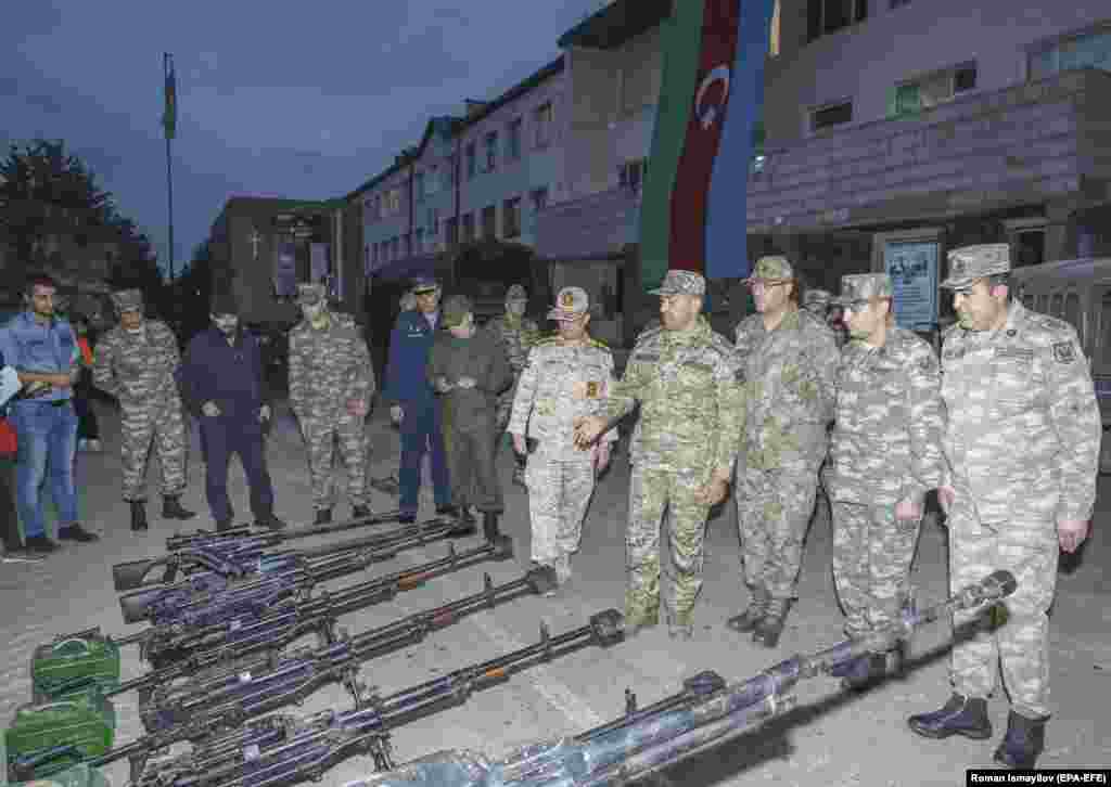 In a photo released on September 24, Azerbaijani military personnel, and one unidentified Iranian serviceman (center) in Susa stand alongside weapons that Azerbaijan says were captured from ethnic Armenian fighters. On September 19, a military operation was launched by Baku against ethnic Armenians in Nagorno-Karabakh. 