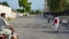 Residents return on a street partially blocked by barbed wire a day after an army cantonment was attacked by a militant suicide squad in Bannu on July 16.