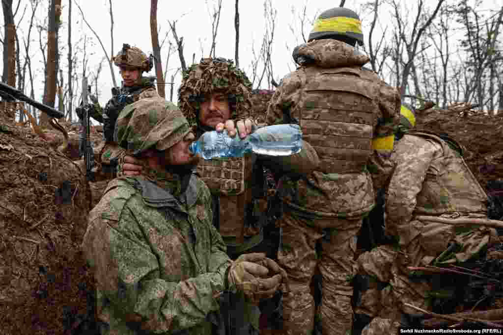 Солдаты ВСУ дают напиться российскому военнопленному. Окрестности Бахмута, май 2023 года.. 
