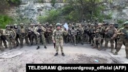 In a video posted on Telegram, the chief of the Russian mercenary group Wagner, Yevgeny Prigozhin, addresses the Russian Army's top brass while standing in front of Wagner fighters at an undisclosed location.