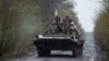 Ukrainian servicemen ride atop an armored fighting vehicle at an unknown location in eastern Ukraine. The image was released on April 19. 