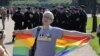 A participant poses with a rainbow flag with Interior Ministry officers in the background during an LGBT rally in St. Petersburg in 2017.
