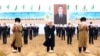 Туркменские старейшины и чиновники на фоне изображения президента Сердара Бердымухамедова, который занял пост в марте 2022 года вместо отца. Собеседники Азатлыка говорят, что портреты Сердара и Гурбангулы Бердымухамедовых висят повсюду, их нет «разве что в туалетах»
