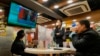 People in a Hong Kong restaurant watch a broadcast as Russian troops invade Ukraine on February 24, 2022.