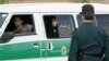 A female officer of Iran's morality police looks out of the back of a police vehicle during a crackdown to enforce the Islamic dress code in Tehran in 2007.