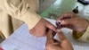 په چارسده کې انتخاباتي افسر د یو ووټر ګوته رنګوي - پخوانی انځور.