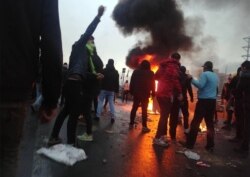Iranian protesters gather around a fire during a demonstration against an increase in gasoline prices in Tehran on November 16.