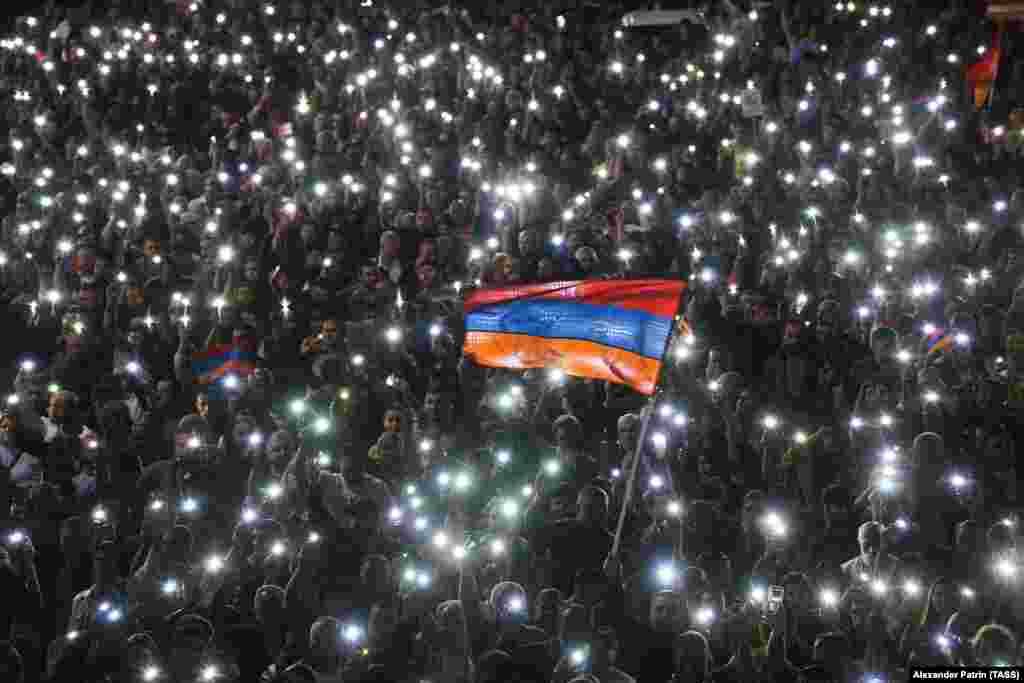 Протестующие зажигают мобильные факелы, маршируя по улице во время протеста оппозиции в центре Еревана 24 мая 2022 года. С 25 апреля по всей Армении прошли акции протеста против трехсторонней встречи между Арменией, Азербайджаном и президентом Армении 24 мая, а таже Совета Европы относительно судьбы Нагорного Карабаха. (ТАСС/Александр Патрин)