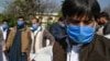 Drivers who work for a Pakistan-based Chinese company wear protective face masks before a check of their temperatures in Islamabad.