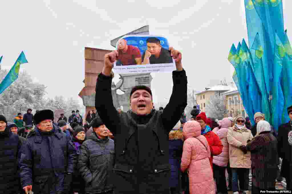 A man in Almaty holds a photo of two ethnic Kazakhs from China facing deportation back to China where many fear they may be sent to "re-education camps". 