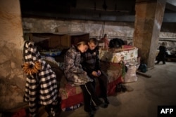 Residents of the Prtrovskyi neighborhood of the city of Donetsk sit in a bomb shelter last November.