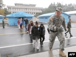 Një ushtar amerikan i prin një grupi turistësh në fshatin e armëpushimit, Panmunjom, në zonën e çmilitarizuar, e cila ndan Korenë e Jugut me atë të Veriut.