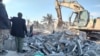 Members of Iraqi Shi'ite Popular Mobilization Forces clean up rubble after a U.S. air strike in Al-Qaim, Iraq, on February 3. 