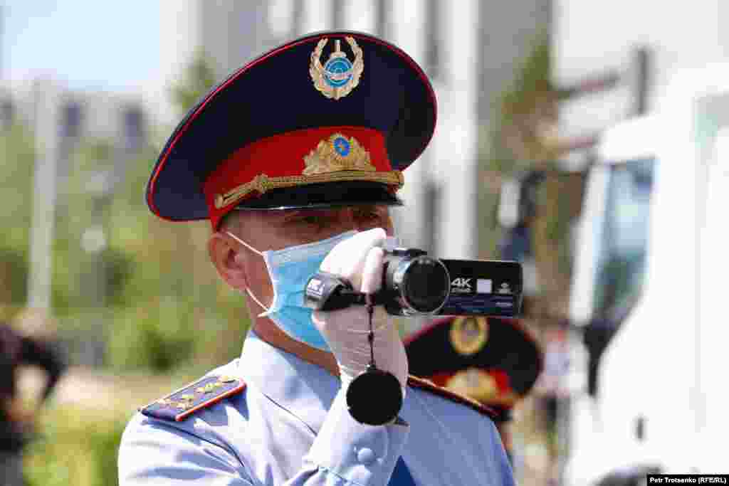 A police officer shoots video at the site of a planned protest rally in Nur-Sultan.