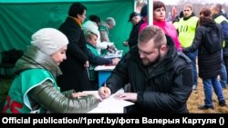 Прапагандыст Рыгор Азаронак ставіць подпіс за аднаго з кандыдатаў у прэзыдэнты Беларусі