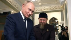Kadyrov (C) shows Koran to Russia's President Vladimir Putin (L) during his visit to Chechnya in Grozny