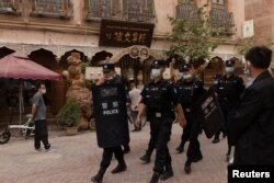 Hytaýyň Sinjiang uýgur awtonom sebitiniň gadymy Kaşgar şäherinde polisiýa işgärleri patrullyk edýär