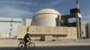 A worker rides a bicycle past the reactor building of the Bushehr nuclear power plant in Iran. (file photo)