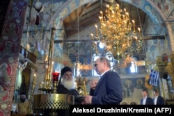 Russian President Vladimir Putin prays during a visit to the monastic community of Mount Athos in Karyes in May 2016.