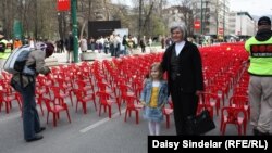 Biba Mehimovic stands with her granddaughter Sara in front of the small red chairs symbolizing the 643 children who died in the siege.