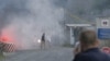 Poliţist kosovar, urmărind devastarea punctului de trecere de la Jarinje, la frontiera cu Serbia, 27 iulie 2011