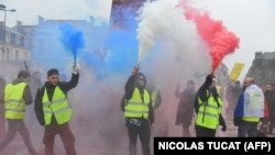 Протестувальники запалюють фаєри кольорів французького прапора під час «Жовтих жилетів» (Gilets jaunes). Бордо, Франція, 22 грудня 2018 року