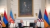 US President Donald Trump (C), Azerbaijani President Ilham Aliyev (L) and Armenian Prime Minister Nikol Pashinyan display the agreement they signed in the State Dining Room of the White House in Washington, DC on August 8, 2025.