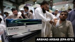 پېښور کې یو روغتیاپال یو کس ته د کووېډ-۱۹ واکسینو ستن لګوي. انځور - ارشیف
