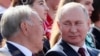 Президент России Владимир Путин смотрит на бывшего президента Нурсултана Назарбаева, прибывшего в Москву и участвующего в торжествах по случаю Дня города. Сентябрь 2019 года.