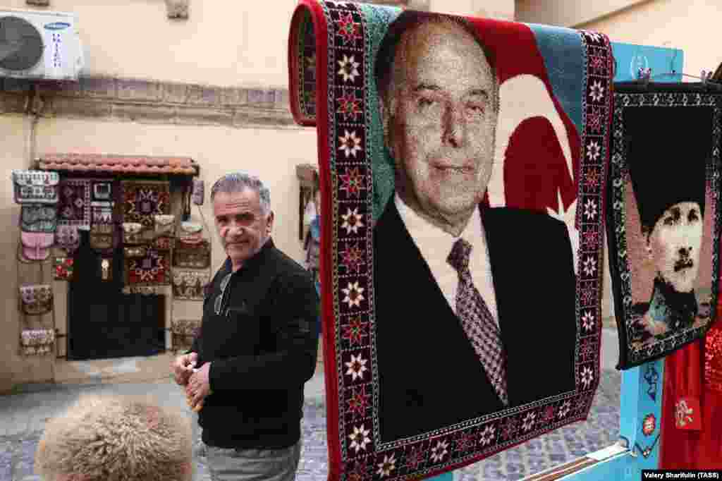 A man selling carpets with the image of former Azerbaijani President Heidar Aliyev (left) and Mustafa Kemal Ataturk, the founder of modern Turkey. Aliyev famously described Turkey and Azerbaijan as "one nation, two states." 