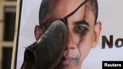A protester hits a portrait of U.S. President Barack Obama with a shoe -- a gesture of insult in the Arab world -- in front of the U.S. Embassy in Cairo last spring.
