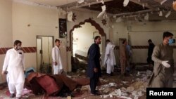  Members of a bomb-disposal unit survey the site after a blast at a mosque in Kuchlak, on the outskirts of Quetta, on August 16.