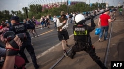 Poliția poloneză reacționînd la scenele de violență de la Varșovia