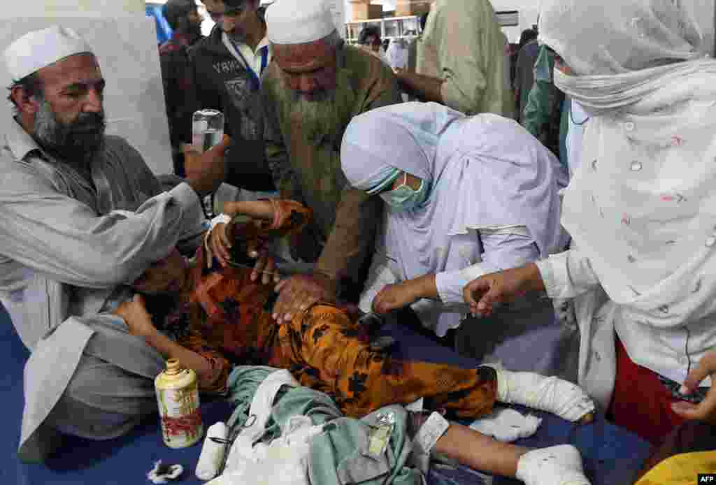 Pakistani paramedics treat an injured girl at a hospital in Peshawar.