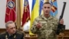 Начальник Генштабу ЗСУ Віктор Муженко (ліворуч) поруч із військовим, який демонструє безшумну снайперську гвинтівку «Вінторез», вилучену у полоненого військовослужбовця. Такі гвинтівки використовує російський спецназ. Київ, 18 травня 2015 року