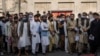 Afghans line up outside the Iranian Embassy in Kabul to request travel visas on September 29.