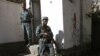 Afghan policemen stand guard near the body of a suicide bomber inside a United Nations compound in Herat.