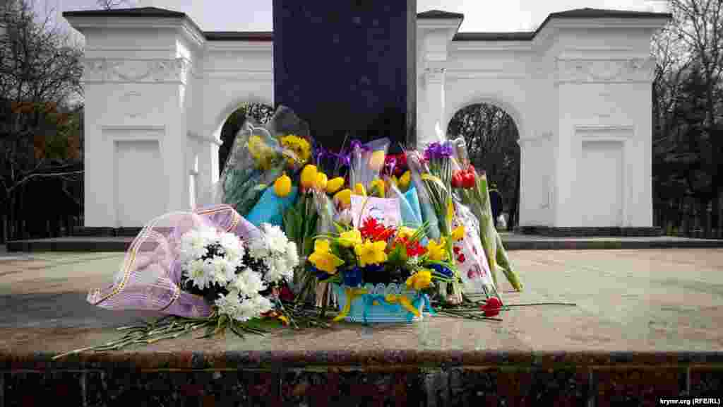 Активісти принесли до пам'ятника квіти, прикрашені синьо-жовтими стрічками