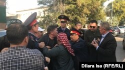 Полиция қызметкерлерінің белсенді Нұржан Мұхамедовті сот залына күштеп апаруға тырысып жатқан сәті. Шымкент, 25 қазан 2019 жыл