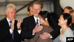Bill Clinton și Al Gore salută ziaristele eliberate la sosirea lor în SUA