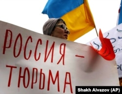 Плакат на акції у Тбіліссі (Грузія) проти агресії Росії щодо України, архівне фото