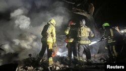 Ukrainian firefighters work on in a residential area hit by a Russian air strike on September 23.