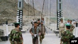 Tajik border guards check identification documents of people crossing the Tajik-Afghan border. (file photo)