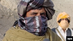 Taliban spokesman Zabiullah Mujahid speaks to a journalist in the mountains of Helmand Province last month.