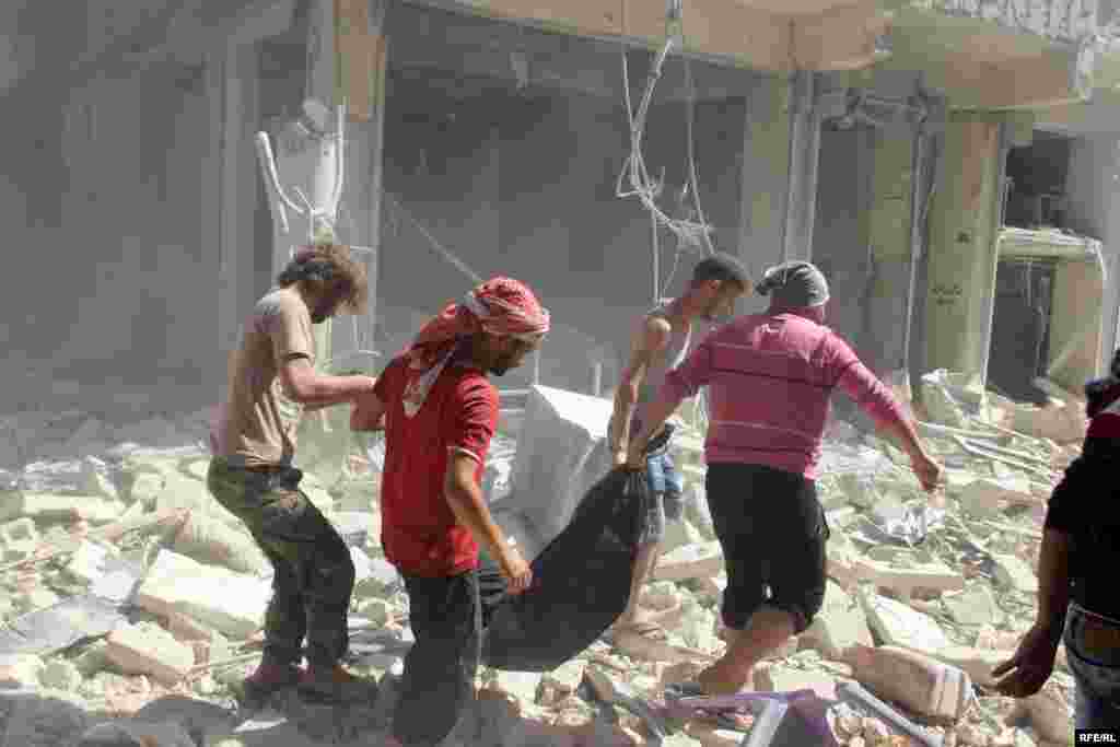 Civilians pull a body from the remains of a shattered building in Aleppo's Bustan al-Qasr district on October 11. 