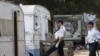 Poliția franceză inspectînd o tabără ilegală de romi la Aix-en-Provence