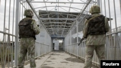 Uzbek border guards keep watch on a bridge across the Kara-Su River border between Kyrgyzstan and Uzbekistan. The Tashkent government is the only former Soviet administration to still require exit visas for its citizens to leave the country.
