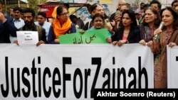 People hold signs to condemn the rape and killing of 7-year-old Zainab Ansari in Kasur, during a protest in Karachi on January 11.